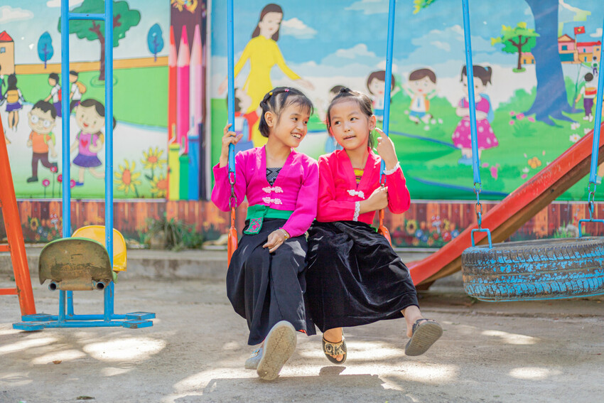 Two children at a slide in a school in Vietnam.
