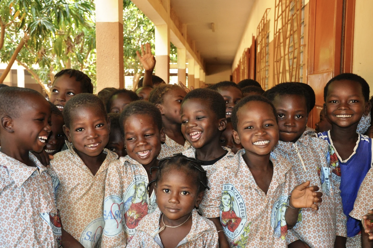 Group of children smiling and looking at the camera.