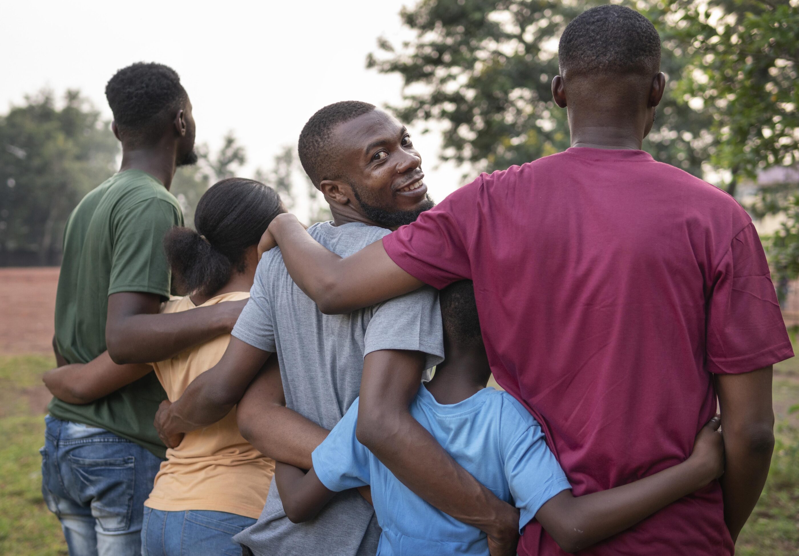 A group of young individuals embracing each other, smiling.